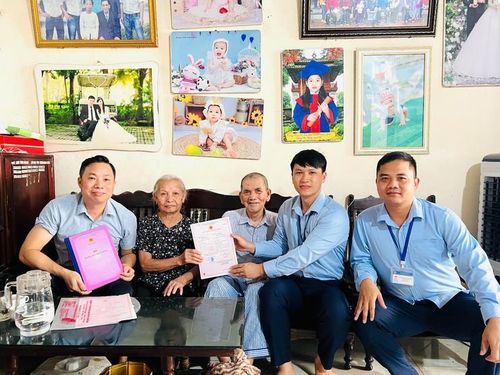 Vợ chồng cụ Dương Văn Lợi vui mừng được Tổ xung kích Điểm hỗ trợ dịch vụ công số Kiều Phú trao Giấy chứng nhận kết hôn ngay tại nhà. Ảnh: Thúy Quỳnh
