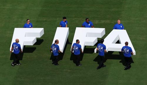 Nhân viên sân cỏ mang logo FIFA trên sân trước trận đấu. Nguồn: Reuters.