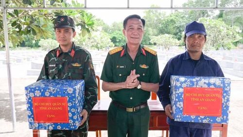 Lãnh đạo Bộ Chỉ huy quân sự tỉnh An Giang tặng quà, động viên đội lấy mẫu ADN hài cốt liệt sĩ tại Nghĩa trang Liệt sĩ Tri Tôn. (Ảnh: PHƯƠNG VŨ)