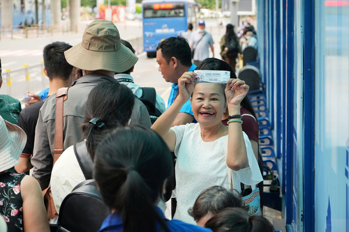  Hành khách đi xe buýt vui mừng chia sẻ phiếu bốc thăm được trúng thưởng trong chương trình tri ân khi đi xe buýt.