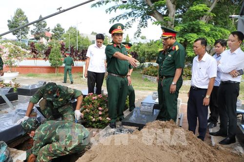 Đoàn công tác kiểm tra công tác lấy mẫu hài cốt liệt sĩ tại Nghĩa trang liệt sĩ Cao Lãnh (xã Mỹ Thọ). Ảnh: Hồng Thái - TTXVN