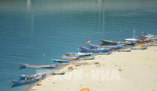 Những chiếc thuyền thúng và ghe đánh cá neo đậu trên vịnh Lăng Cô lặng lẽ trên mặt biển với nhiều màu sắc hòa trộn với nhau. Ảnh: Văn Dũng-TTXVN