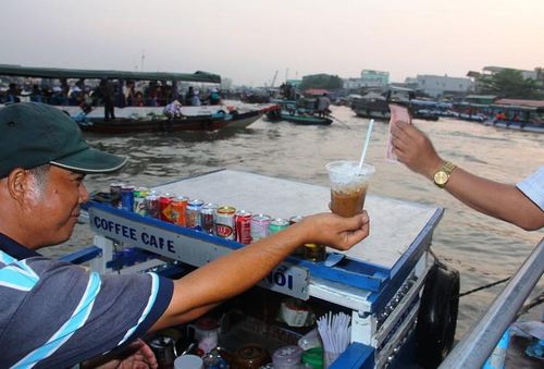 Du khách thưởng thức cà phê sáng trên chợ nổi. Ảnh: charmantsuites.com