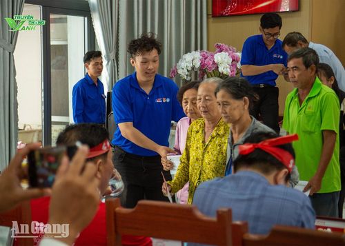 Sinh viên Trường Đại học Tôn Đức Thắng hỗ trợ tặng quà cho hộ nghèo, hộ cận nghèo, hộ có hoàn cảnh khó khăn xã An Châu. Ảnh: PHƯƠNG LAN
