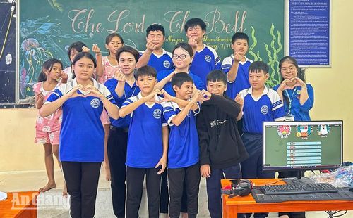 Sinh viên Trường Đại học An Giang chụp ảnh lưu niệm với học sinh xã Núi Cấm. Ảnh: PHƯƠNG LAN