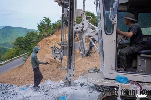Công nhân đang nỗ lực khoan những khối đá lớn để tạo mặt bằng.