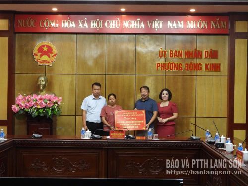 Đại diện UBND phường Đông Kinh và lãnh đạo Công ty Cổ phần Sản xuất và Thương mại Lạng Sơn trao kinh phí cho hộ nghèo