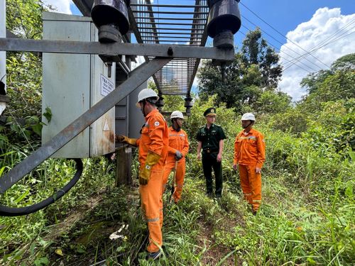 Anh Voòng cùng đồng nghiệp và Bộ đội Biên phòng kiểm tra trạm biến áp trong rừng