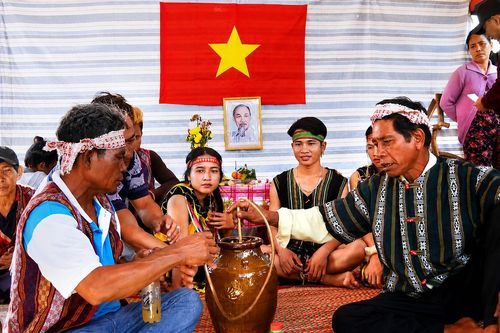 Già làng đang giới thiệu cho các thế hệ con cháu về rượu cần, một nét văn hóa truyền thống của dân tộc Raglai và mong thế hệ trẻ cố gắng gìn giữ, phát huy