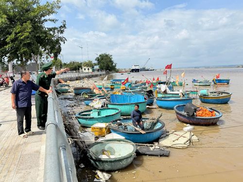 Lực lượng Trạm Kiểm soát Biên phòng Phan Thiết đang hướng dẫn chủ thúng di dời phương tiện đến vị trí neo đậu phù hợp