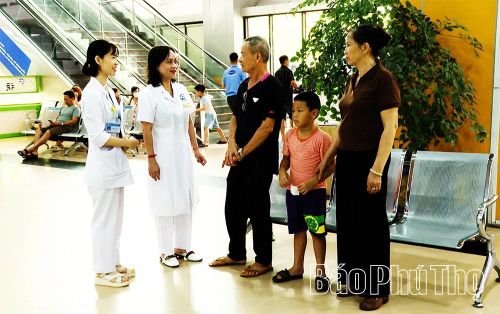 Lãnh đạo Bệnh viện Đa khoa Vĩnh Phúc trao đổi với người bệnh tại khu vực đăng ký khám, chữa bệnh khi triển khai chính sách BHYT mới.
