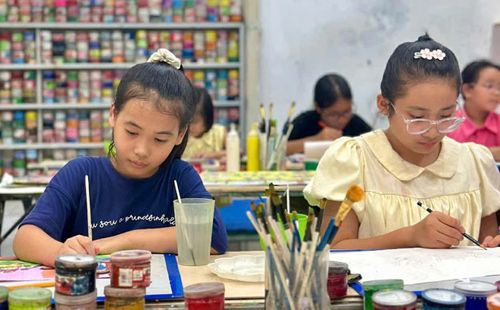 Em Vũ Tố Uyên, học sinh lớp 5A, Trường Tiểu học Núi Voi (bên trái) và bạn vẽ tranh tại Trung tâm Nghệ thuật Ngôi Sao Lấp Lánh, phường Linh Sơn.