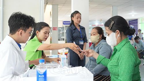 Lực lượng đoàn viên - thanh niên và nhân viên y tế nhiệt tình hướng dẫn bà con hoàn tất thủ tục đăng ký tại bàn tiếp nhận.