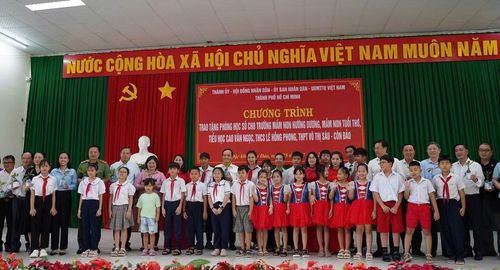 Lãnh đạo TPHCM, các đơn vị tài trợ và trường học chụp ảnh lưu niệm cùng các em học sinh - Ảnh: ĐTCC