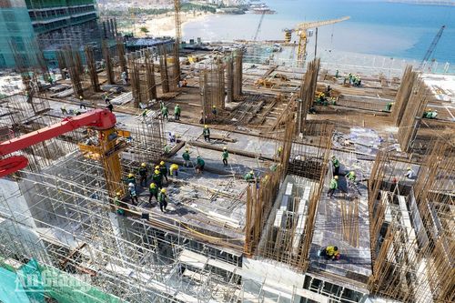 Công nhân thi công cốt thép trên sàn công trình, hàng chục kỹ sư, công nhân mặc đồng phục, đội mũ bảo hộ làm việc giữa rừng thép chờ đổ bê tông. Ảnh: THỤY DU.