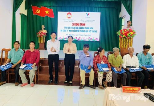 Lãnh đạo xã và nhà tài trợ tặng quà cho gia đình chính sách.