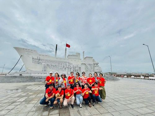 Đoàn cán bộ ngân hàng chụp ảnh tại Tượng đài kỷ niệm chuyến tàu tập kết ra Bắc ở Cà Mau - Ảnh: B.Minh