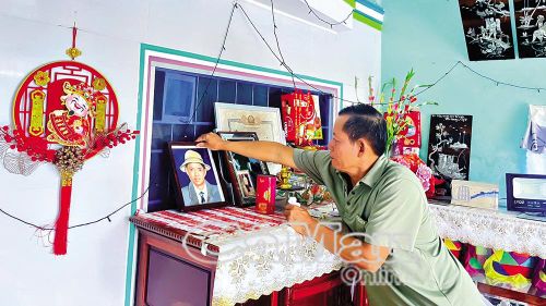 Ông Đoàn Văn Chiến lau di ảnh của liệt sĩ Đoàn Văn Út.