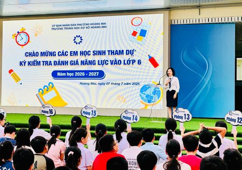 Bà Chu Thị Xuân Hường, Hiệu trưởng Trường THCS Hoàng Mai chào đón học sinh tham dự kỳ kiểm tra đánh giá năng lực vào lớp 6 năm học 2026-2027. Ảnh: HM.