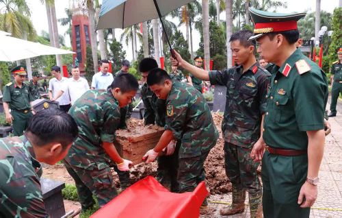 Thực hiện quy trình khai quật, đưa hài cốt liệt sĩ chưa xác định danh tính về khu vực lấy mẫu sinh phẩm tại Nghĩa trang liệt sĩ Nhổn (phường Tây Tựu). Ảnh: Văn Điệp – TTXVN