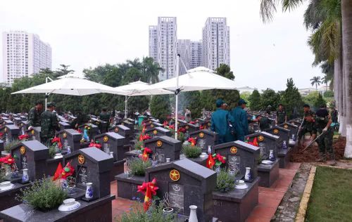 Thực hiện quy trình khai quật, đưa hài cốt liệt sĩ chưa xác định danh tính về khu vực lấy mẫu sinh phẩm tại Nghĩa trang liệt sĩ Nhổn (phường Tây Tựu). Ảnh: Văn Điệp – TTXVN