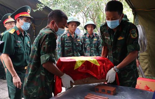 Thực hiện quy trình khai quật, đưa hài cốt liệt sĩ chưa xác định danh tính về khu vực lấy mẫu sinh phẩm tại Nghĩa trang liệt sĩ Nhổn (phường Tây Tựu). Ảnh: Văn Điệp – TTXVN
