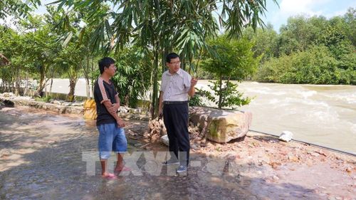 Lãnh đạo Chi nhánh Dầu Tiếng - Phước Hòa (Công ty Trách nhiệm hữu hạn Một thành viên Khai thác thủy lợi Miền Nam) trao đổi với người dân về hoạt động kinh doanh tại hành lang thoát lũ hồ Dầu Tiếng. Ảnh: Minh Phú - TTXVN