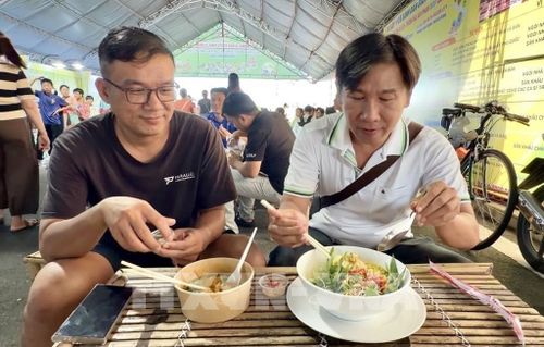 Du khách hào hứng thưởng thức bún kèn Hà Tiên món ăn mang đậm hương vị biển cả của vùng đất Hà Tiên, An Giang. Ảnh: Thanh Sang - TTXVN