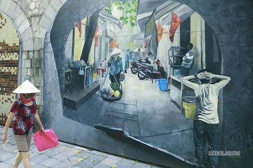 Tranh bích họa tái hiện nhịp sống Hà Nội xưa trên một ô vòm cầu. Ảnh: T.Anh