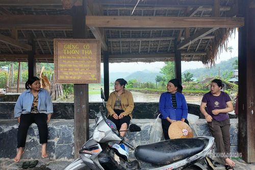 Người dân trò chuyện bên giếng cổ thôn Tha. Ảnh: T. Anh