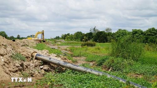 Công trình cao tốc đang thi công khiến nông dân gặp khó về tưới tiêu, không có đường cho máy móc vào đồng ruộng. (Ảnh: Nhựt An/TTXVN)