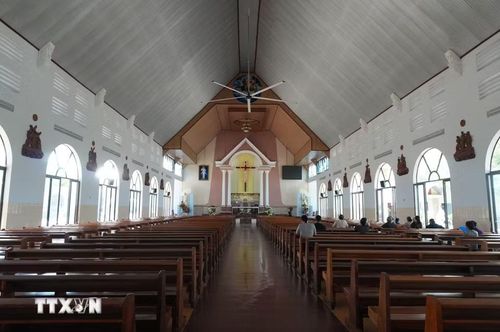 Người dân làng Tân Hà đi lễ tại Nhà thờ Tân Hà, công trình nằm trong trung tâm của ngôi làng hình bát quái. (Ảnh: Nguyễn Dũng/TTXVN)