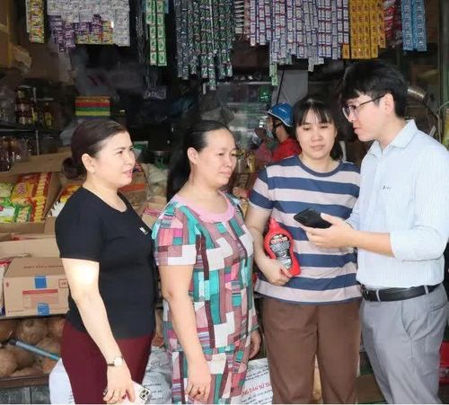 Tiểu thương chợ Đồng Xoài được hướng dẫn cài đặt phần mềm. Ảnh: Quang Minh.