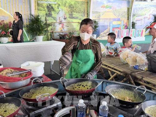 Đầu bếp khéo léo đổ cùng lúc 10 chảo bánh xèo, tạo nên không gian trình diễn ẩm thực sôi động. Ảnh: Thanh Sang - TTXVN