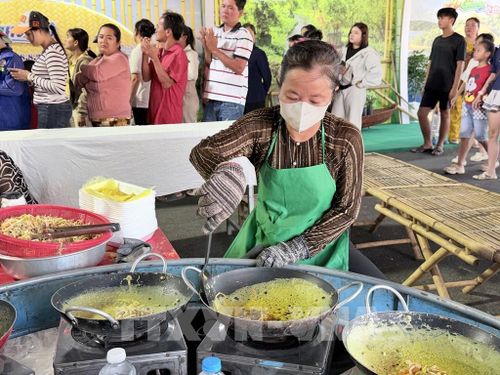 Đầu bếp chế biến bánh xèo trên chảo nóng, tạo nên món ăn với màu sắc và hương vị hấp dẫn. Ảnh: Thanh Sang- TTXVN
