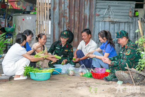 Bộ đội cùng thanh niên địa phương chuẩn bị “Bữa cơm đoàn kết quân-dân” tại gia đình thương binh Nguyễn Văn Thảo.
