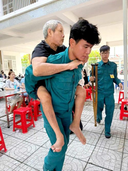 Người dân gặp khó khăn trong việc đi lại được hỗ trợ đưa đến điểm khám sức khỏe. Ảnh: Khánh Chi
