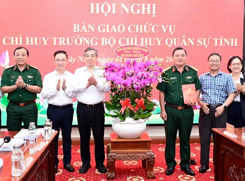 Đồng chí Nguyễn Phước Lộc và đồng chí Đặng Minh Thông tặng hoa chúc mừng Đại tá Trần Văn Cư nhận nhiệm vụ mới. Ảnh: VĂN MINH