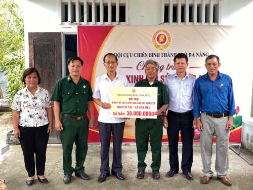 Phó Chủ tịch Hội Cựu chiến binh thành phố Huỳnh Bá Thành (thứ 3, bên trái qua) trao kinh phí hỗ trợ sửa chữa nhà cho hội viên khó khăn. Ảnh: ĐVCC
