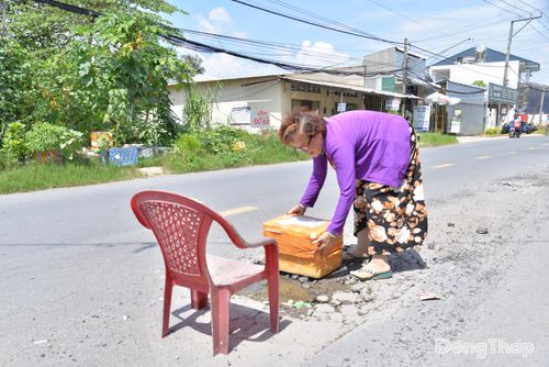 Bà Ánh phải đặt ghế, thùng xốp tại ổ gà trên đường phía trước nhà để cảnh báo người đi đường.