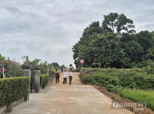 Ông Nguyễn Văn Thuận (giữa) cùng người dân đi trên con đường được mở rộng từ sự đồng thuận hiến đất, đóng góp công và kinh phí của người dân - Ảnh: K.S
