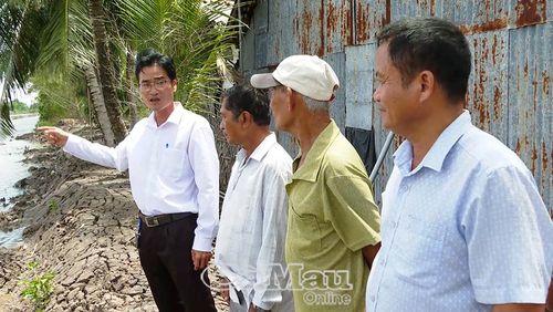 Ðồng chí Trần Văn Nguyên, Phó Bí thư Chi bộ, Trưởng ấp Xóm Mới (bìa trái) trao đổi với nông dân về mô hình nuôi tôm ít thay nước kết hợp sử dụng chế phẩm sinh học.