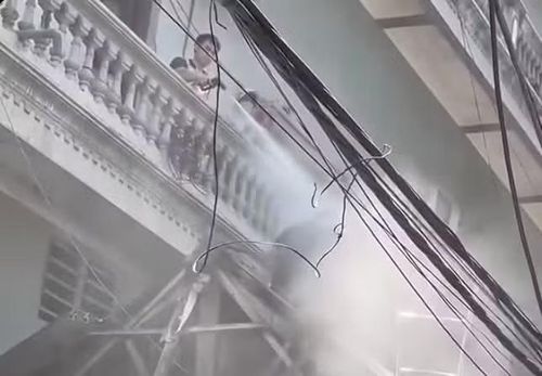 Mạnh dùng vòi xịt nước xịt vào người công nhân tháo dỡ mái nhà hàng xóm. Ảnh cắt từ video.