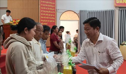 Phó Chủ tịch Hội Nạn nhân chất độc da cam/dioxin tỉnh Cà Mau Nguyễn Xuân Tình trao quà cho 50 nạn nhân da cam tại xã Đầm Dơi. Ảnh: TTXVN phát