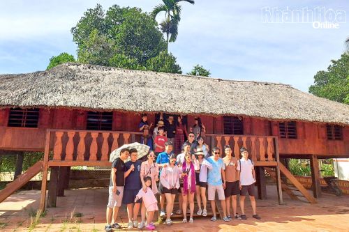 Du khách chụp hình lưu niệm tại Nhà dài thôn Hòn Dung.