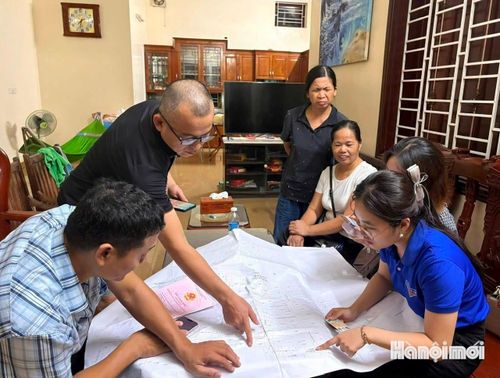 Tổ công tác làm việc buổi tối, hỗ trợ người dân cập nhật dữ liệu đất đai tại khu dân cư. Ảnh: Tuệ Lâm
