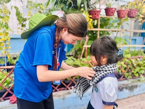 Ông Phương Hồng Ngọc đeo khăn rằn cho em học sinh tại Trường Tiểu học Thạnh An.