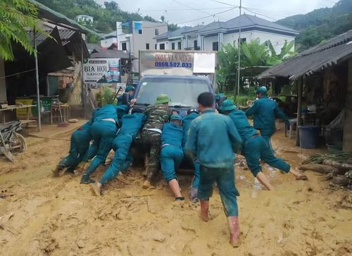 Lực lượng dân quân tự vệ hỗ trợ người dân di chuyển tài sản.