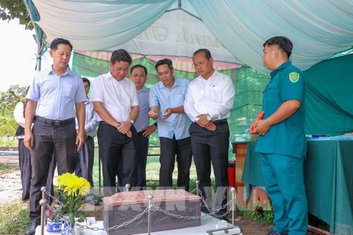 Phó Chủ tịch UBND xã Tân Biên Trần Đức Tuấn (thứ 3, phải sang) báo cáo về công tác lấy mẫu ADN phục vụ công tác xác định danh tính hài cốt liệt sĩ. Ảnh: Giang Phương – TTXVN