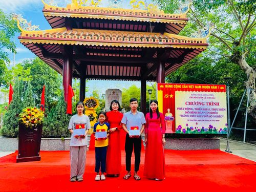 Lãnh đạo xã Hòa Tiến tặng quà cho học sinh có hoàn cảnh khó khăn trong khuôn khổ triển khai mô hình “Đảng viên giúp đỡ hộ nghèo”. Ảnh do đơn vị cung cấp